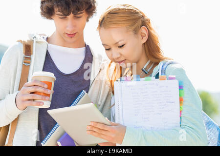 Maschio e femmina amici utilizzando la tavoletta digitale presso il college campus Foto Stock