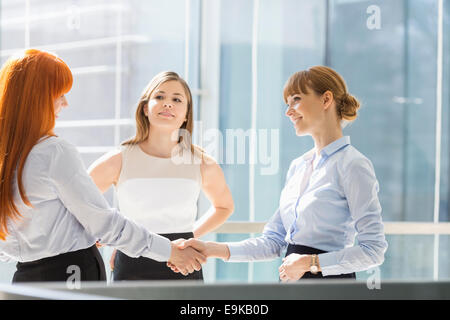 Imprenditrici stringono le mani in office Foto Stock