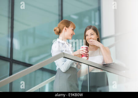 Imprenditrici spettegolare pur avendo caffè sui passi in ufficio Foto Stock