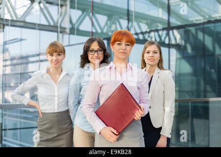 Ritratto di fiducioso imprenditrici in piedi insieme in ufficio Foto Stock