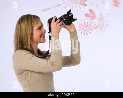 Vista laterale della giovane donna fotografare vari patters su sfondo bianco Foto Stock