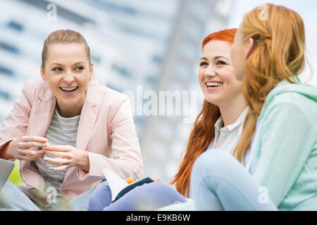 Felice giovani collegio femminile amici che studiano all'aperto Foto Stock