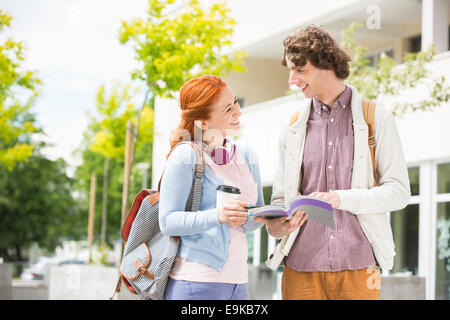 Felice giovane uomo e donna studiando insieme al college campus Foto Stock