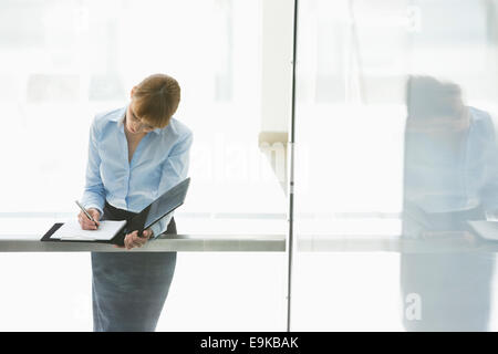 Imprenditrice la scrittura del documento di Office Foto Stock