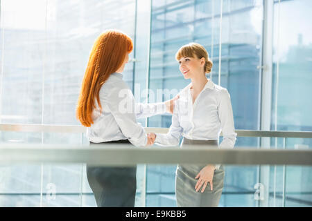 Imprenditrici stringono le mani in office Foto Stock