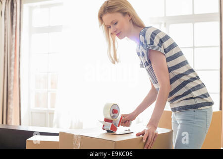 Donna imballo scatola di movimentazione a casa Foto Stock