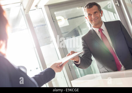 Imprenditore documento di ricezione dai receptionist in office Foto Stock