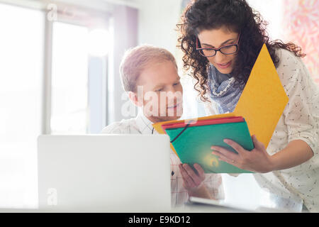 Attività creativa i colleghi a discutere su file in office Foto Stock