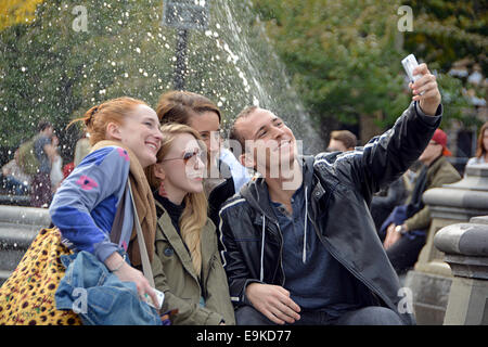 Un gruppo di turisti prendendo un selfie vicino alla fontana di Washington Square Park nel Greenwich Village di New York City Foto Stock