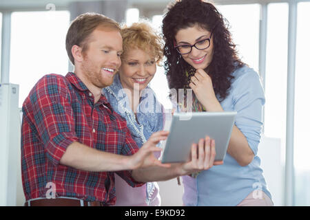 Imprenditrici con il collega di sesso maschile con Tablet PC in ufficio creativo Foto Stock