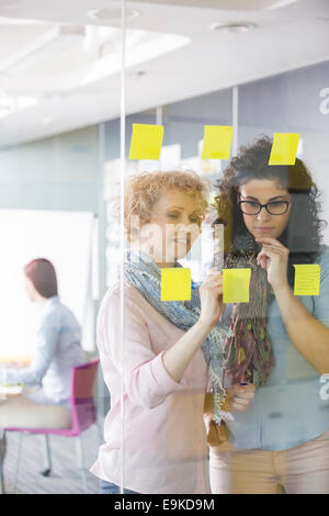 Imprenditrici il brainstorming con sticky notes in ufficio Foto Stock