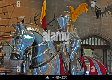 Il Castello di Warwick - un modello di cavaliere sul cavallo, entrambi in armatura scintillante, sul display. Inghilterra, Regno Unito. Foto Stock