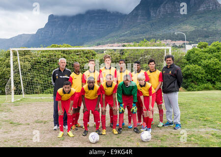 Youth football team (U15) con allenatori pone di fronte a un obiettivo di Cape Town, Sud Africa Foto Stock