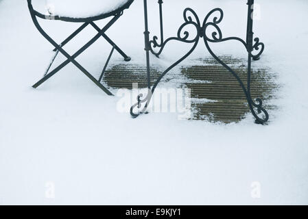 Dettagli di mobili da giardino su strade coperte di neve decking in legno. Foto Stock