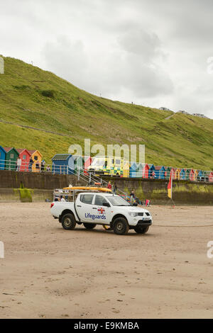 Utility RNLI veicolo parcheggiato sulla spiaggia di Whitby, N Yorks, UK. Un NHS ambulanza è in background. Foto Stock