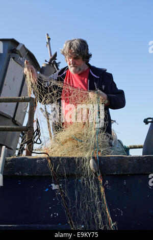 Hastings fisherman pascere le sue reti sulla Città Vecchia Stade beach East Sussex England Regno Unito. Foto Stock