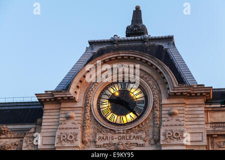 Illuminazione serale del famoso e antico orologio sulla parete del museo di Orsay a Parigi Foto Stock