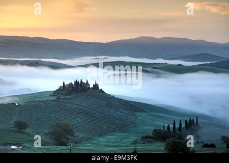 Il Belvedere agriturismo in Val d'Orcia con nebbia mattutina, San Quirico d'Orcia, Toscana, Italia Foto Stock