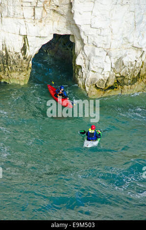 Kayak da mare passando attraverso un arco di roccia presso Old Harry Rocks, vicino a Swanage, Dorset. Foto Stock