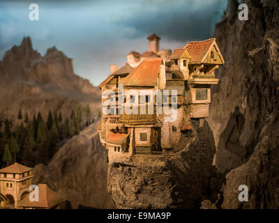 Modello in miniatura di un piccolo borgo sulla sommità di una sezione di roccia in montagna Foto Stock