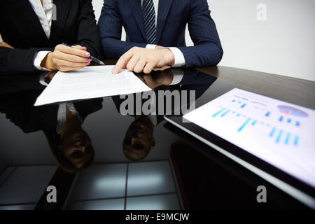 Business Partner per le mani durante la lettura del contratto Foto Stock