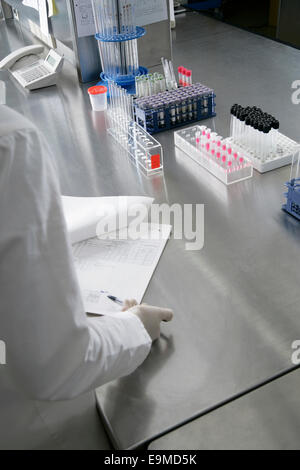 Un tecnico esaminando un grafico di medico Foto Stock