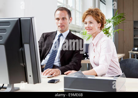 Un imprenditore e imprenditrice lavorando insieme a un computer Foto Stock