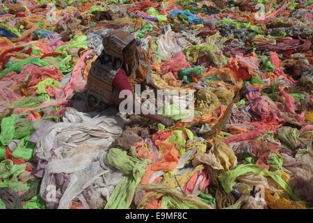 Dacca in Bangladesh. 30 ott 2014. Una donna di asciugatura panni utilizzabile sotto il sole raccolti dai rifiuti graments panni accanto a capi di abbigliamento di Dhaka. © Zakir Hossain Chowdhury/ZUMA filo/Alamy Live News Foto Stock