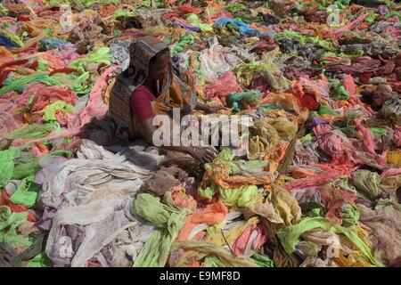 Dacca in Bangladesh. 30 ott 2014. Una donna di asciugatura panni utilizzabile sotto il sole raccolti dai rifiuti graments panni accanto a capi di abbigliamento di Dhaka. © Zakir Hossain Chowdhury/ZUMA filo/Alamy Live News Foto Stock