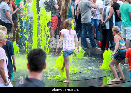 DORDRECHT, Paesi Bassi - 20 Maggio 2014: i bambini che giocano nel verde acqua colorata nella fontana sulla piazza principale durante le celebrazioni Foto Stock