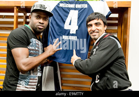 Potsdam, Germania. 26 ott 2014. Hassan dalla Macedonia, pullman di Welcome-United-Nulldrei e portiere Deuton posano con il jersey sponsorizzata negli spogliatoi in Karl-Liebknecht stadion di Potsdam, Germania, 26 ottobre 2014. Come dei rifugiati recentemente formano una propria squadra di calcio a SV Babelsberg 03. Foto: Oliver Mehlis/dpa/Alamy Live News Foto Stock