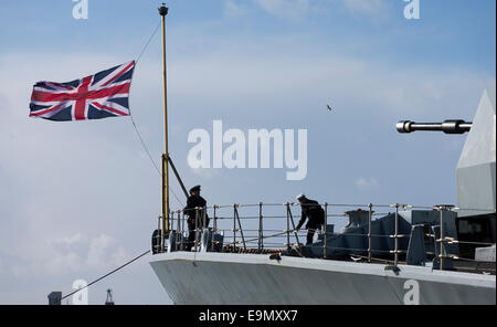 I marinai sollevare la Union Jack sulla prua del tipo 23 fregata HMS Richmond ritorna a Portsmouth Royal Navy Base Foto Stock