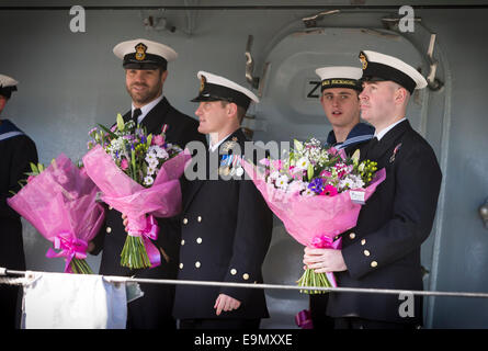 Ufficiali con mazzi di fiori di attendere pazientemente a bordo come il tipo 23 fregata HMS Richmond ritorna a Portsmouth Royal Navy Bas Foto Stock