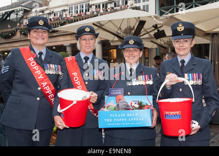 Il Covent Garden di Londra, Regno Unito. Il 30 ottobre, 2014. Essi Royal British Legion Papavero del giorno a Londra centrata attorno a Covent Garden dove gruppi musicali, cori, classica e pop musicisti che hanno intrattenuto la folla come Air Force il personale che esegue le benne di donazione venduto papaveri, sperando di sollevare in eccesso di £ 1 milioni. Nella foto: il personale dell'Air Force aiutano a portare in secchi pieni di donazioni da parte del pubblico. Credito: Paolo Davey/Alamy Live News Foto Stock