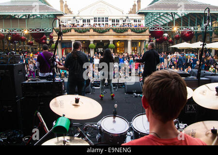 Il Covent Garden di Londra, Regno Unito. Il 30 ottobre, 2014. Essi Royal British Legion Papavero del giorno a Londra centrata attorno a Covent Garden dove gruppi musicali, cori, classica e pop musicisti che hanno intrattenuto la folla come Air Force il personale che esegue le benne di donazione venduto papaveri, sperando di sollevare in eccesso di £ 1 milioni. Nella foto: Rock band Mixtape Nazione esegue per la folla in Covent Garden. Credito: Paolo Davey/Alamy Live News Foto Stock