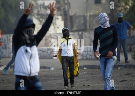 Gerusalemme. Il 30 ottobre, 2014. Mascherato giovani palestinesi si scontrano con forze di sicurezza israeliane in Abu Tor, quartiere di Gerusalemme est, su Ott. 30, 2014. La prominente di estrema destra attivista ebreo Yehuda Glick era criticamente shot tardi Mercoledì sera dopo un evento politico che propugnano la presenza ebraica a Gerusalemme il Monte del Tempio, una costante fonte di discordia tra ebrei e arabi. Credito: Xinhua/Alamy Live News Foto Stock