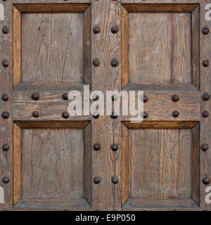 Dettaglio della vecchia porta solido. Il legno e la porta di metallo con punte metalliche cercando usurato e una schifezza. Parte dell antico castello o fortezza. Foto Stock