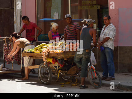 Street la frutta e la verdura venditore utilizzando un carrello a mano per visualizzare la sua merce Foto Stock