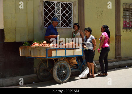 Street la frutta e la verdura venditore utilizzando un carrello a mano per visualizzare la sua merce Foto Stock