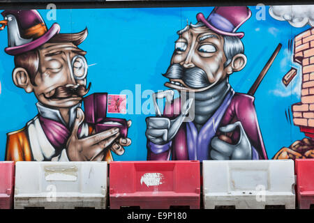 Close-up di un murale colorato dotato di due uomini anziani indossare cappelli sui cartelloni temporaneo intorno a un edificio sito. Foto Stock