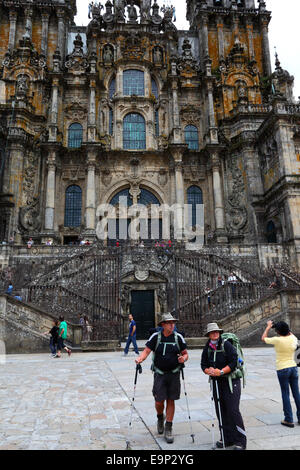 Gli escursionisti terminano la strada di San Giacomo di fronte alla cattedrale, Praza do Obradoiro / Plaza del Obradoiro, Santiago de Compostela , Galizia , Spagna Foto Stock