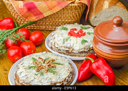 Torte di fegato con aglio, salsa di aneto, noci, pomodori, peperoni dolci e verdi su un tavolo di legno. Foto Stock