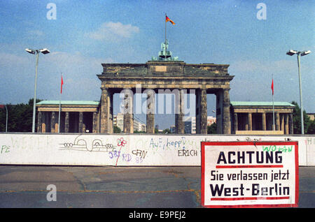 Un segno di fronte al muro di Berlino e Porta di Brandeburgo legge 'Achtung ! Verlassen Sie jetzt Berlino Ovest" (lit. "Attenzione! Ora di lasciare Berlino Ovest") di Berlino, Germania, 29 agosto 1986. Foto: Wolfgang Kumm/dpa Foto Stock