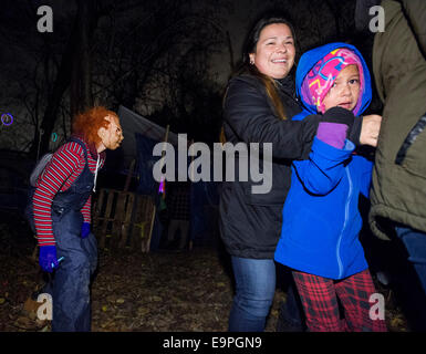 Montreal, Canada. 30 ott 2014. Una bambina spaventata reagisce in Halloween Haunted boschi della riserva Mohawk di Kahnawake vicino a Montreal, Canada, Ottobre 30, 2014. Più di dieci volontari che indossano costumi spaventosi spaventare e intrattenere i visitatori durante la stagione di Halloween qui. I due giorni di attività raccoglie anche cibo e donazioni per il cibo locale di banca. Credito: Andrew Soong/Xinhua/Alamy Live News Foto Stock