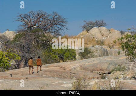 San bushman trackers camminando sulla antica affioramento di granito di Kubu Island (Lekhubu), Makgadikgadi Pan, Botswana Foto Stock