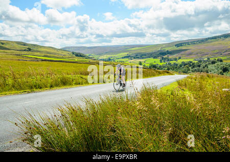 Ciclista femmina scalata del Stang nel Yorkshire Dales Foto Stock