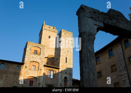 San Gimignano, Toscana, Italia. Soleggiato torri medievali che si affaccia su Piazza della Cisterna, xiii secolo ben in primo piano. Foto Stock