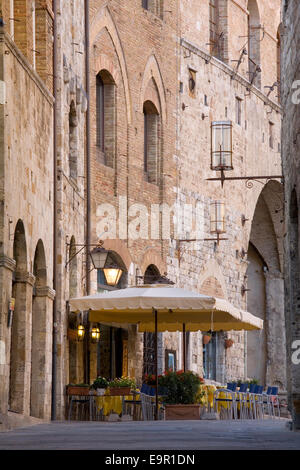 San Gimignano, Toscana, Italia. Vista lungo la Via San Matteo, tipica caffetteria sul marciapiede prominente. Foto Stock