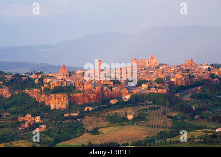 Orvieto, Umbria, Italia. Vista sullo skyline della città attraverso il paesaggio agricolo, il tramonto. Foto Stock