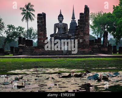 Statua del Buddha e le rovine di Wat Mahathat tempio di Sukhothai, Thailandia. Foto Stock